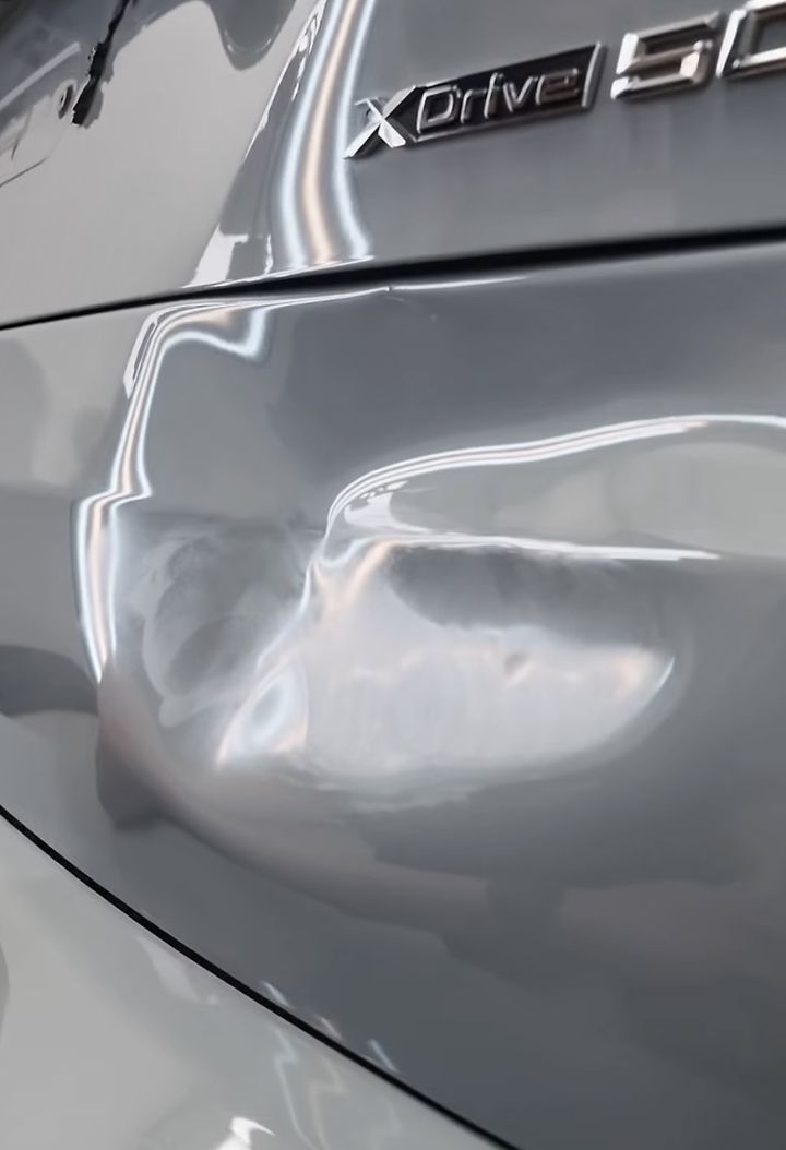 Hayon de BMW enfoncé sous le monogramme, lu sous la lampe